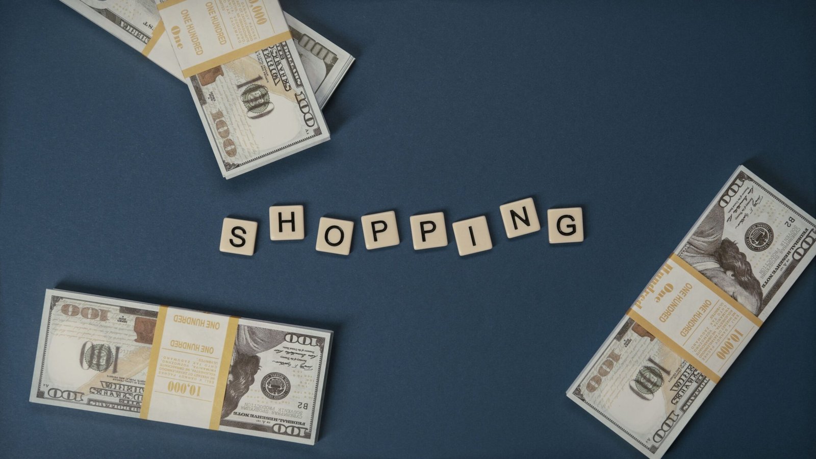 Stacked US dollars around shopping letters on a blue background.